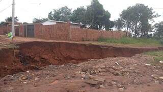 Cratera ameaça engolir muro de casa de morador (Foto: Mariely Barros) 