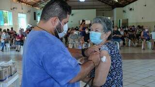 Idosa sendo vacinada contra a covid-19, em Campo Grande (Foto: Karine Matos)