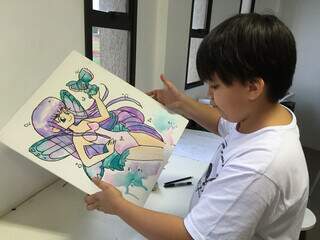 Criança segura ilustração de personagem colorida. (Foto: Divulgação)