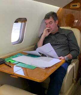 Postagem nas redes sociais do governador Eduardo Riedel mostra ele analisando documentos dentro do jatinho a caminho de São Paulo. (Foto: Instagram)