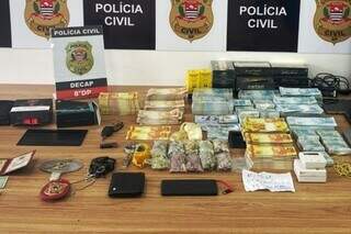 Celulares, distintivos, algemas, drogas e dinheiro falso encontrados na casa de suspeito (Foto: Divulgação)