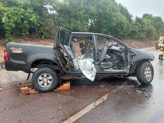 Caminhonete Hilux destruída e corpo de uma das vítimas. (Foto: Sidney Assis, de Coxim)