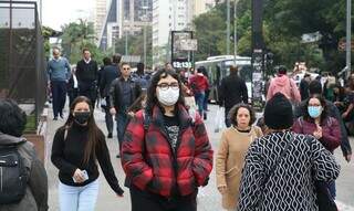 Moradores caminham de máscara pelas ruas. (Foto: Agência Brasil)