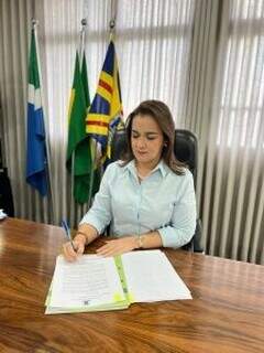 Prefeita Adriane Lopes assinando papéis. (Foto: Secom)