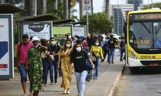 Passageiros de ônibus caminham de máscara. (Foto: Agência Brasil)