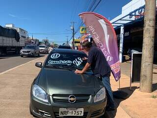 Funcionário anuncia preço no vidro do carro para atrair clientes (Foto: Natália Olliver)