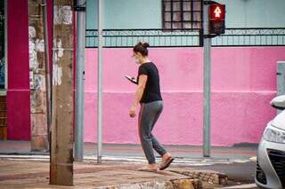 Usuária de celular caminhando em rua da Capital (Foto: Henrique Kawaminami)