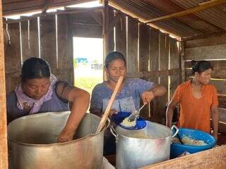 Indígenas servindo almoço de inauguração da cozinha comunitária na retomada, neste domingo (22). (Foto: Marcelo Batarce)