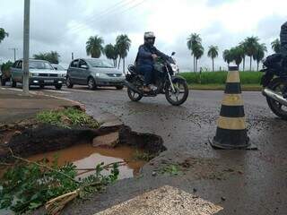 Asfalto molhado, com buraco na esquina (Foto: Cleber Gellio)