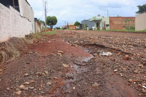 Em rua que asfalto ficou só na promessa, o jeito é tirar barro na enxada 