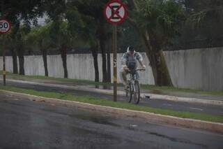 Ciclista enfrentando a chuva em Campo Grande na manhã desta segunda-feira (23) (Foto: Henrique Kawaminami)