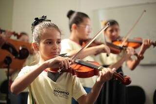 Criança toca violino duramte aula do Instituto Moinho (Foto: Moinho Cultural)
