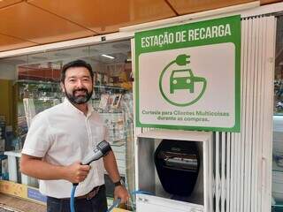 Empresário Lindolfo Martin Filho mostra ponto de recarga gratuito em frente à loja dele, na Avenida Afonso Pena (Foto: Caroline Maldonado)