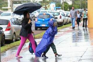 Mãe e filho chegando na escola em dia chuvoso (Foto: Henrique Kawaminami)