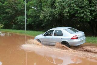 Carro se arrisca na calçada para evitar passar por dentro da área inundada. (Foto: Kísie Ainoã)