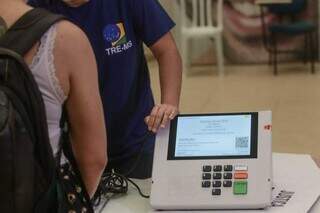 Funcionário do Tribunal Regional Eleitoral de Mato Grosso do Sul faz última checagem da urna eletrônica antes de entregar para presidente de seção. (Foto: Marcos Maluf/Arquivo)