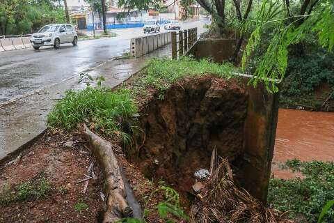 Em área de risco de inundação, lama obstrui avenida e ponte pode ser "engolida"
