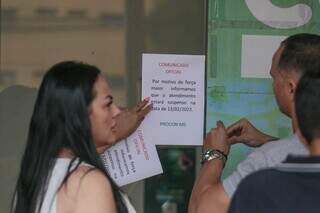 Funcionária coloca cartaz sobre fechamento do Procon após morte. (Foto: Marcos Maluf)