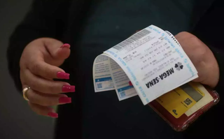 Apostadora com bilhetes da Mega-Sena em Campo Grande. (Foto: Arquivo/Marcos Maluf)