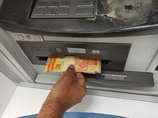 Cliente saca dinheiro em caixa eletrônico. (Foto: Kísie Ainoã/Arquivo)