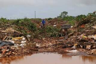 Carlos Eduardo se perde em meio a tanto entulho (Foto Henrique Kawaminami/Campo Grande News)