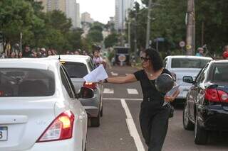 Mulher com roupa preta entregando mensagens em homenagem à menina (Foto: Marcos Maluf)