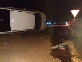 Veículo capotou após colidir no trevo do Taquarussu. Bebidas alcoólicas estão próximas ao carro. (Foto: Divulgação)