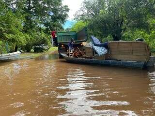 Moradora registrou o uso de barco para transportar móveis em Águas de Miranda. (Foto: Reprodução)