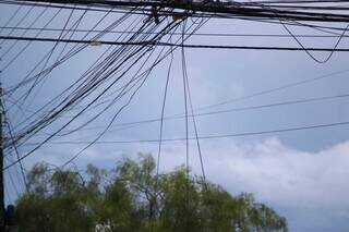 Sempre há fios soltos nos postes no bairro Nova Campo Grande. (Foto: Alex Machado)