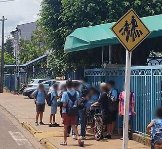 Crianças esperando início das aulas no sol em calçada. (Foto: Direto da Ruas)