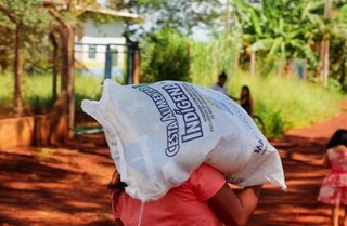 Indígena carrega cesta básica entregue pelo Estado. (Foto: Arquivo/Monique Alves)