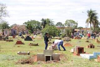 Familiares cuidando de túmulo no Cemitério Santo Amaro (Foto: Paulo Francis)