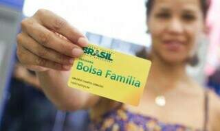 Mulher segura cartão antigo do Bolsa Família (Foto: Divulgação)
