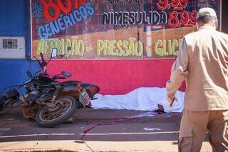 Motociclista caiu na calçada de farmácia, no Aero Rancho. (Foto: Henrique Kawaminami)