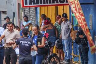 Esposa da vítima (blusa azul) é amparada no local do crime. (Foto: Henrique Kawaminami)