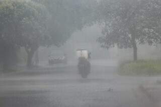 Motociclista em meio a chuva em rua do bairro São Lourenço, em Campo Grande (Foto: Alex Machado)