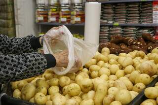 Consumidora escolhendo batatas em supermercado de Campo Grande (Foto: Paulo Francis)