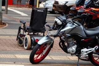 Cadeira de rodas da vítima e parte dianteira da moto danificada após colisão (Foto: Alex Machado)
