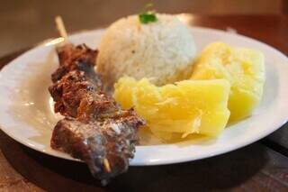 Espetinho com mandioca e arroz integra menu da casa. (Foto: Juliano Almeida)