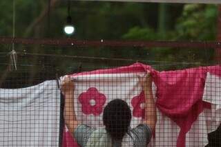 Dona de casa estende roupa, enquanto ao fundo a lâmpada está ligada. (Foto: Marcos Maluf)