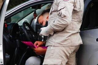 Bombeiro recolhe pistola encontrada no carro após quebrar vidro para acordar condutor (Foto: Alex Machado)