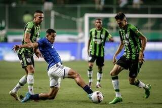 Jogador do Cruzeiro perde bola em meio a marcação de jogadores do América-MG. (Foto: Divulgação)