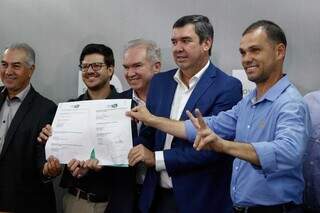 Governador Eduardo Riedel e representantes do Grupo Way mostram contrato assinado. (Foto: Alex Machado)