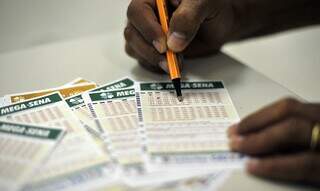 Apostador escolhe números da sorte em canhoto da Mega-Sena. (Foto: Marcelo Casal Jr/Agência Brasil)