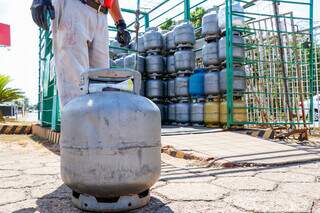Gás de cozinha, de 13 kg, sendo manuseado por funcionário em revendedora de Campo Grande (Foto: Henrique Kawaminami)