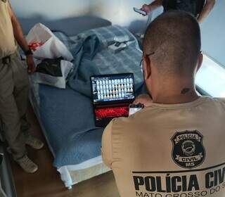 Policiais no quarto de douradense preso com material de pornografia infantojuvenil (Foto: Divulgação)