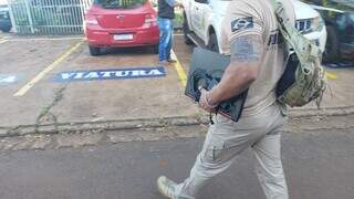 Policial chega à delegacia carregando notebook apreendido em operação (Foto: Adilson Domingos)