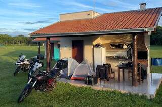 Motos equipadas estacionadas em pousada de Mato Grosso do Sul e cabanas montadas no chão (Foto: Divugação/Terax)