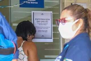 Aviso de greve na porta de um posto de saúde 24 horas de Campo Grande, em fevereiro, quando categoria paralisou pressionando por pagamento de insalubridade. (Foto: Henrique Kawaminami/Arquivo)