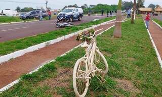 Monumento em homenagem a ciclistas mortos e ao fundo a moto que bateu em bicicleta (Foto: Adilson Domingos)